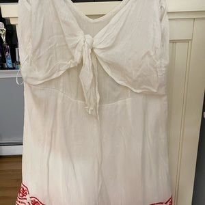 White romper with tie in the front and red lacing